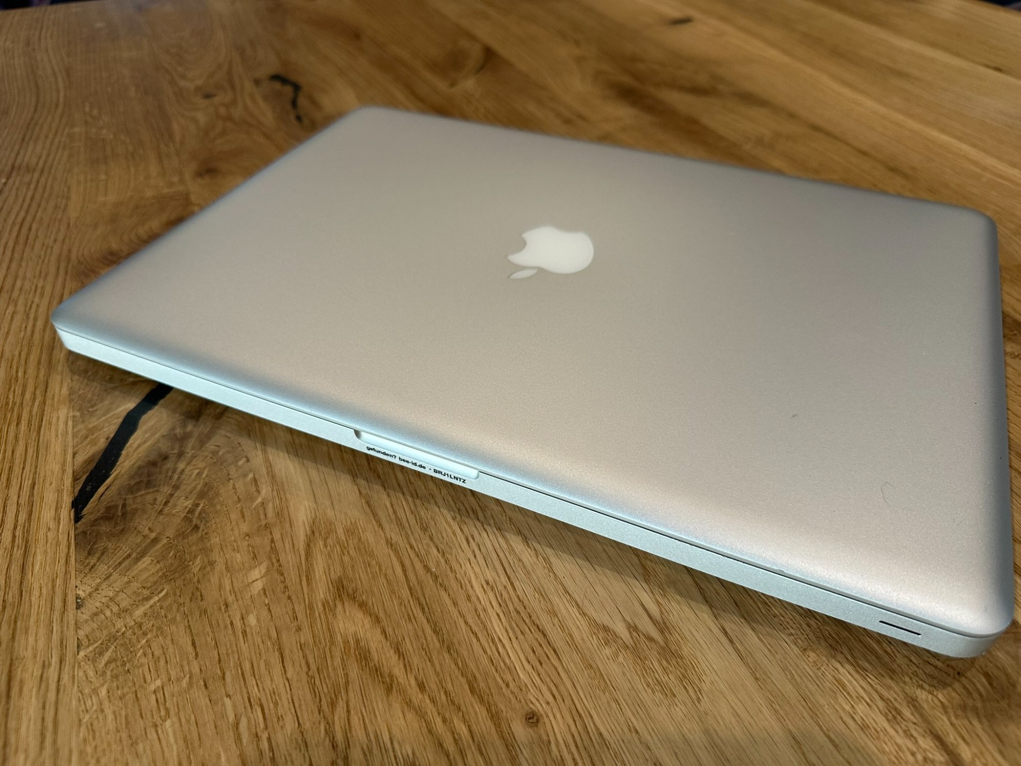 Bee-ID Mini-UV-Sticker an der Seite eines MacBook – so klein, dass er kaum auffällt